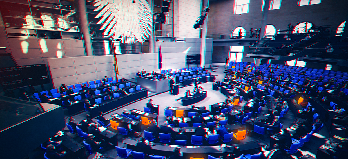 Ansicht des Plenarsaals im Bundestag, einige Sitze sind orange hervorgehoben.