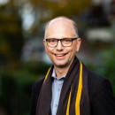 Außenaufnahme von Dr. Till Steffen, Justizsenator, mit einem Jacket und einem gestreiften Schal.