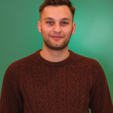 Can Diego Aru Can Aru vor einem grünen Hintergrund