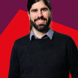 Christian Arnd Mein Foto, freundlich lächelnd, zugewandt vor einem rot und dunkelrotem Hintergrund.