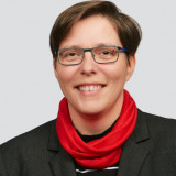 Claudia Engelmann trägt auf ihrem Profilbild kurzes Haar, eine Brille, einen roten Rundhalsschal und ein schwarzes Jackett. 