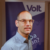 Daniel Stiefenhofer Portraitfoto vor Volt-Fahne