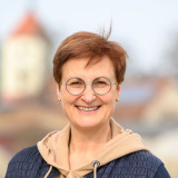Annett Klingsporn Annett Klingsporn, lebensfrohe Frau mit Brille vor der Kirche meines Heimatortes - Porträtfoto
