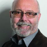 Günter Herbig Da lacht er, zwischen Haarkranz und Vollbart, dunkel gerandete Brille