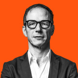 Klaus von Birgelen, ÖDP-München, mit kräftiger Brille, schwarzweiß auf Orange