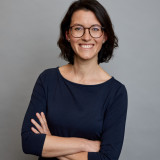 Lisett Stuppy Lisett mit verschränkten Armen. Sie trägt ein dunkelblaues Shirt mit Dreiviertel-Ärmeln und lächelt herzlich.