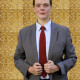 Buchwald in grauem Anzug, blauem Hemd, roter Krawatte vor goldener Tapete (Foto: A.Rost)