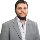Bild Leon Suchanek, ein weißes Hemd mit zwei offenen Knöpfen und einem grauem Sakko.