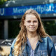 Auf dem Bild ist Jana Brix zu sehen, die vor dem Eingang zum Ubahnhof Mierendorffplatz steht und leicht lächelt.