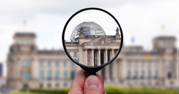 Bundestag mit Ausschnitt, der durch eine Lupe vergrößert wird