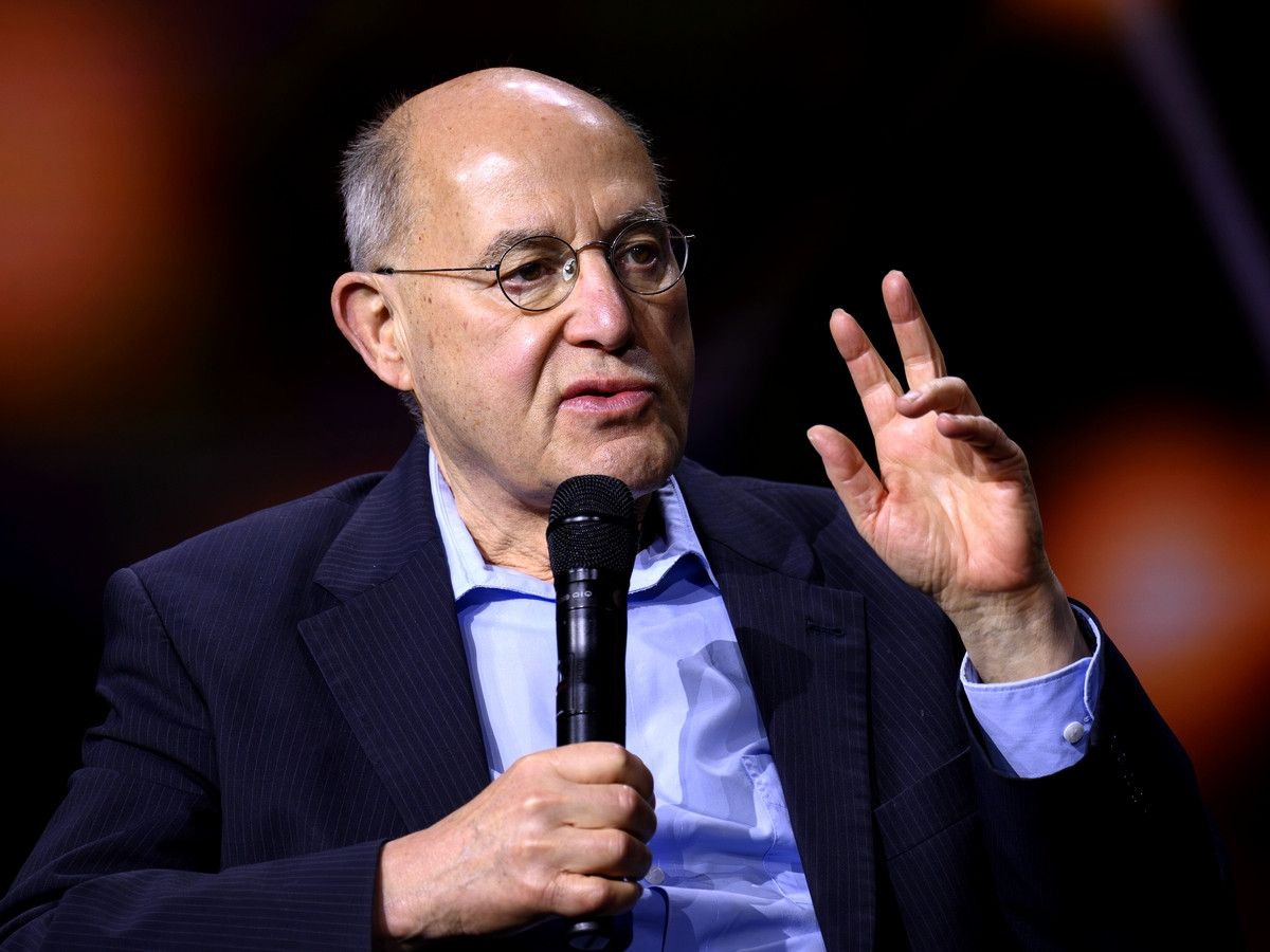 MdB Gregor Gysi (Linke) bei einer Podiumsveranstaltung mit Mikrofon in der Hand