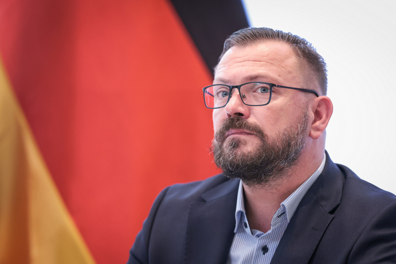 Patrick Harr sitzt vor einer Deutschlandfahne